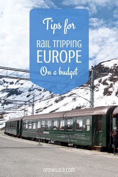 a green train traveling down tracks next to snow covered mountains with text overlay that reads tips from a european rail trip on a budget