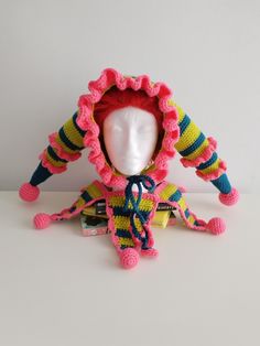 a crocheted doll with a hat on it's head sitting next to a white mannequin