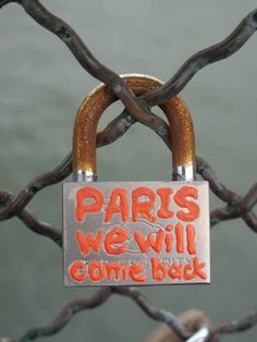 a sign that says paris we will come back on a chain link fence