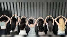 five women standing in a row with their hands on their hipss, making the shape of a heart