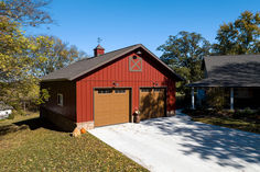 a red barn with two garages in the front and one on the other side