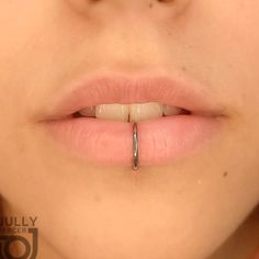 a close up of a person's mouth with a nose piercing