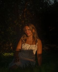 a woman sitting in the grass at night