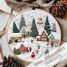 a hand embroidered christmas scene with houses and trees