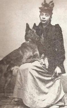 an old black and white photo shows a man in costume with a dog on his lap