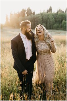 a man and woman standing in tall grass