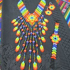 a black crocheted tablecloth with colorful beads on it and an elaborate necklace