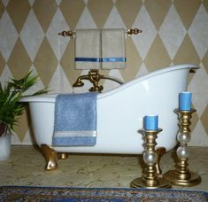 a white bath tub sitting on top of a bathroom floor next to a potted plant