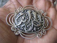 An antique sterling silver Arabic Ottoman Islamic brooch. It has a lovely traditionally detailed center with a nice scalloped border. The brooch measures 2'' x 1 1/2''. There are 3 marks on the back of the brooch that can not be recognized, however, it has been tested and found to be solid sterling silver. It weighs 9.2 grams. Traditional Hallmarked Brooches For Anniversary, Ornate Silver Engraved Brooches, Classic Silver Brooch, Silver Medallion Brooches As A Gift, Traditional Silver Brooches For Anniversary, Traditional Engraved Brooches For Gift, Engraved Silver Oval Brooches, Antique Silver Brooches With Intricate Design, Classic Silver Brooches With Intricate Design