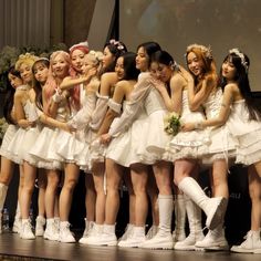 a group of young women standing on top of a stage