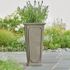 a tall planter sitting on top of a stone floor