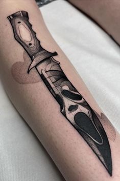 a tattoo with a knife on the arm