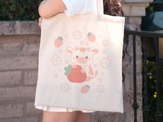 Hi! Thank you for stopping by Alyne and Co. ❤️ 🌟 WHAT YOU'LL RECEIVE - A Lightweight and Compact Tote Bag - Made from 100% Cotton  - Reinforced Handle Stitching  - Please note: Due to monitor differences, actual colors may vary slightly from what appears online. 🌟 SIZE: - ONLY AVAILABLE IN ONE SIZE  - Tote Size: 15.75 inch (Height) by 15.25 inch (Width) - Handle Length: 21.5 inches 🌟 SHIPPING INFO: - This Product is Made-To-Order for each one of our customers - Processing time: 1-3 business days - US delivery time: 2-7 business days. - International delivery time: 7-21 business days. - Printed, Packaged, And Shipped From the USA with love ❤️ 🌟 CARE INSTRUCTIONS: - Pretreat visible stains with stain remover - Mix warm water with laundry detergent and clean the bag with a terry washcloth Cow Kawaii, Kawaii Tote Bag, Strawberry Kawaii, Kawaii Strawberry, Kawaii Bag, Strawberry Cow, Flower Tote Bag, Tote Bag Aesthetic, Flower Tote