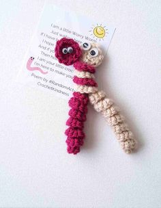 a crocheted toy with eyes on it's end and a card attached to it