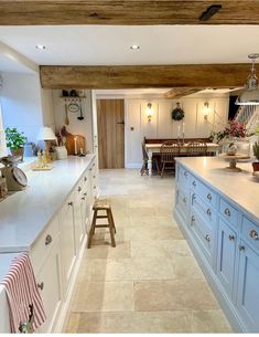 a large kitchen with blue cabinets and white counter tops