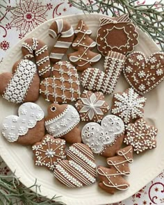 a white plate topped with lots of different kinds of gingerbread cut out hearts and snowflakes