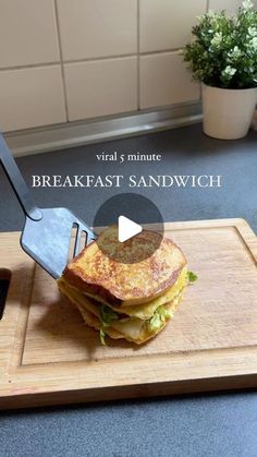 a sandwich is being cut on a cutting board with a knife and some sort of utensil