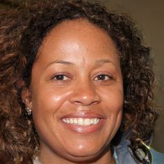 a woman with curly hair smiling at the camera