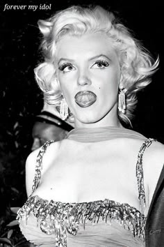 marilyn monroe is posing for the camera with her tongue out