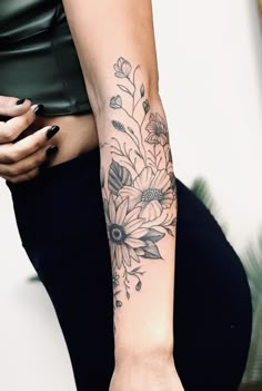 a woman's arm with a flower tattoo on the left side of her arm