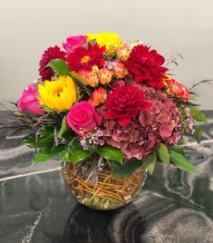 a vase filled with lots of colorful flowers