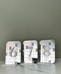 three mirrored numbers are sitting on a table