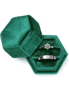 an open green velvet ring box with a diamond in it's center and inside