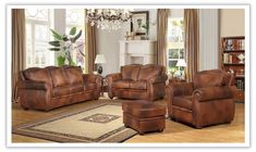 a living room filled with brown furniture and a chandelier hanging from the ceiling