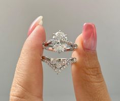 a woman's hand holding two engagement rings