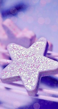 there is a star shaped cookie on top of toothbrushes with pink and white sprinkles