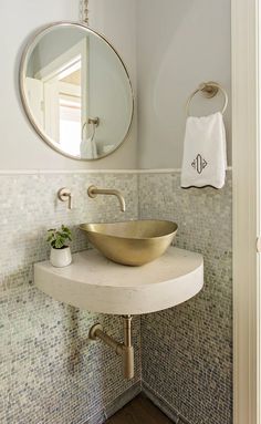 a bathroom sink sitting under a round mirror