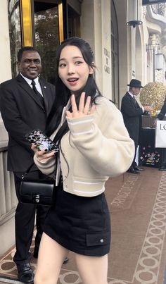 a woman in short black skirt standing next to a man