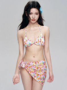 Embrace the sun with confidence in our Floral Halter Neck Bikini featuring a charming side tie sarong that adds a touch of elegance to your beach day ensemble. This three-piece swimwear set boasts a playful floral print with a flattering fitted design. Crafted for comfort and style, the triangle bikini top includes soft cups for support, without the need for underwires, ensuring a natural and comfortable fit. The matching sarong accentuates the hips with its side tie detail, lending a breezy and Tie Sarong, Swimwear Sets, The Triangle, Wireless Bra, Swimwear Collection, Sarong, Three Piece, Beach Day, Halter Neck