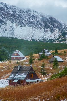 a snowy mountain range with houses in the foreground