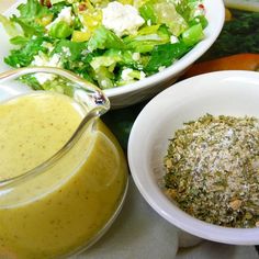 there are two bowls with salad and dressing on the table