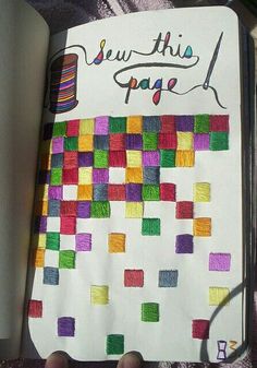 someone is holding a notebook with colored squares on it and writing sew this page