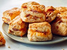 a plate full of biscuits covered in cheese and bacon