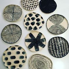 nine black and white plates are arranged in a circle on a table with circles painted on them