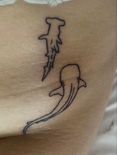 a tattoo on the back of a woman's stomach shows a dolphin and a tree