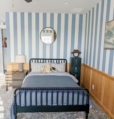 a bedroom with blue and white striped walls