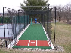 a baseball field with a batting cage in the middle