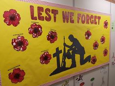 a bulletin board with the words, let's we forget and flowers on it