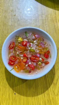 a white bowl filled with vegetables on top of a wooden table