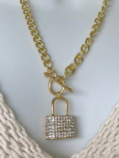 "18K Gold Toggle Necklace with Rhinestone Lock on one side and rows of small hearts on the other side. It's an eye catching piece to add to your jewelry collection. This chain and pendant give you two looks with one piece.  Beware wearing this may get you a lot of attention and compliments.  Chains (Gold or Silver) - Geometric link chain - 18K Plated - 21.06\" long   - Toggle closure (adds to the look) - Chunky chain - Chain is light weight Lock (Gold or Silver) - This is a unique lock one side has rhinestones and the other has small cut out hearts. Making it two different lock looks.  - 1.25\" H x 1.02\"L - Weight 59.4g Packaging & Shipping - Arrives in velvet pouch - Ships in bubble package - Please check estimated shipping arrival.  Remember your Sweetheart this Valentine's Day with jew Necklace Lock, Lock Chain, Padlock Necklace, Turquoise Drop Earrings, Lock Necklace, Toggle Necklace, Unisex Gift, Valentines Necklace, Rhinestone Heart