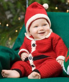 a baby wearing a santa suit sitting on top of a green chair