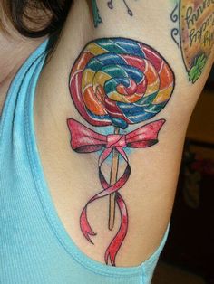 a woman with a colorful lollipop tattoo on her shoulder