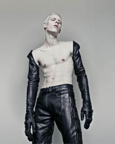 a man with no shirt wearing black leather pants