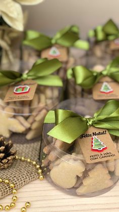 several small glass containers filled with cookies on top of a wooden table next to pine cones