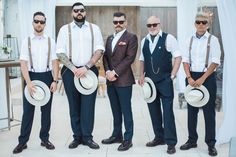 a group of men standing next to each other in suits and ties with hats on