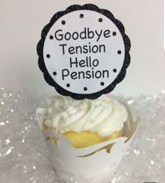 a cupcake with white frosting on top sitting in a paper container that says goodbye tension, hello pension